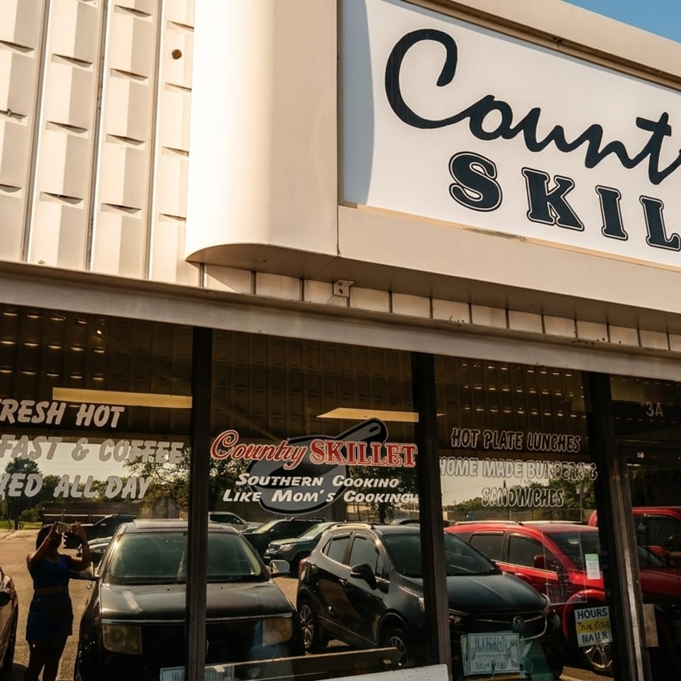 Country Skillet restaurant exterior with prominent sign, brick facade, and reflections of parked cars.